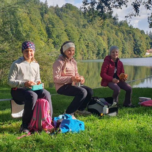Bild von Kindern mit Jause an einem See
